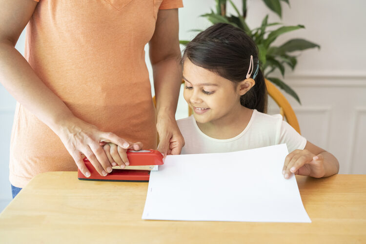 一位母亲将一本书钉在一起。