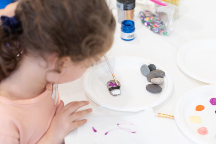 女孩用画笔画岩石。