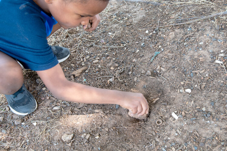 孩子用石头挖洞。