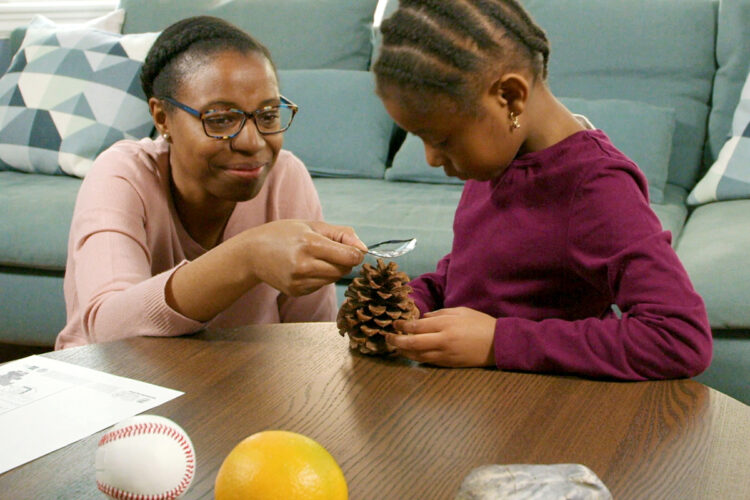 放大镜活动中，女儿用儿童放大镜检查物体。