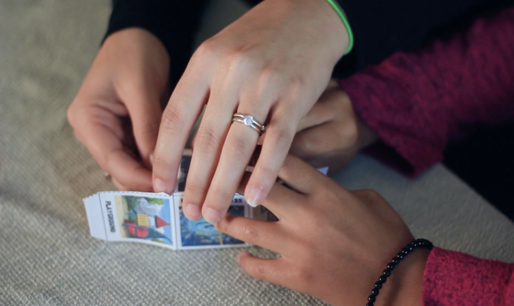 孩子和成人一起合作完成故事立方体的折叠。