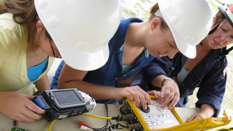 女孩为机器人编程的图片。