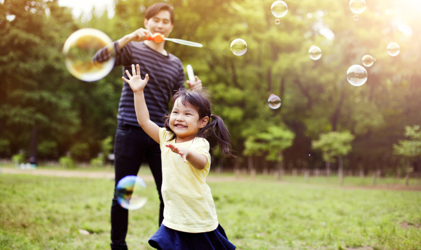 Image of father and daughter blowing bubbles.