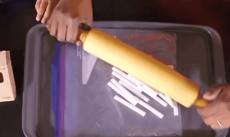 用擀面杖将粉笔放入塑料袋中压碎。